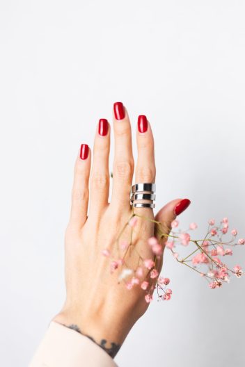 soft gentle photo woman hand with big ring red manicure hold cute little pink dried flowers white1 scaled e1739967503509